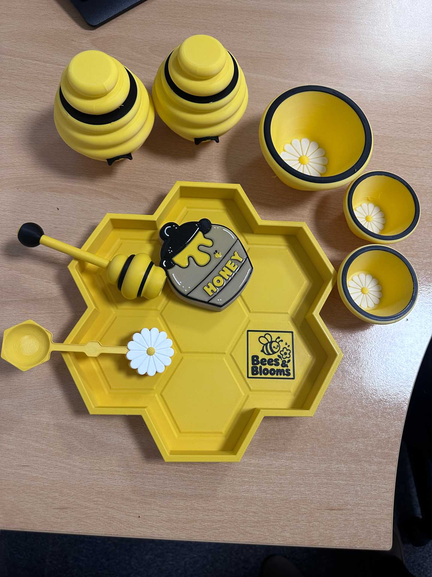 Overhead view of the Honey Bee Playset laid out with tray, honey pot, dipper, flower spoon, beehives and nesting bowls